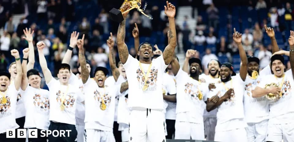Joueur levant le trophée avec son équipe célébrant