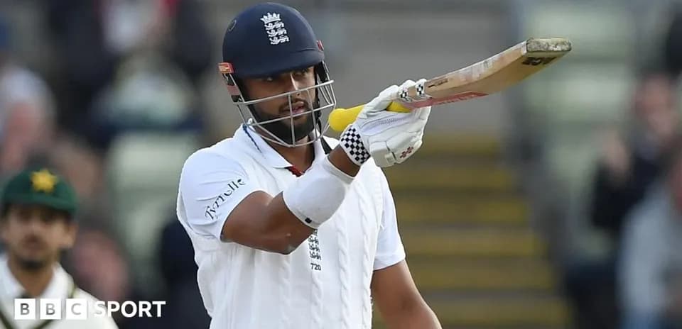 Joueur de cricket anglais levant sa batte au stade