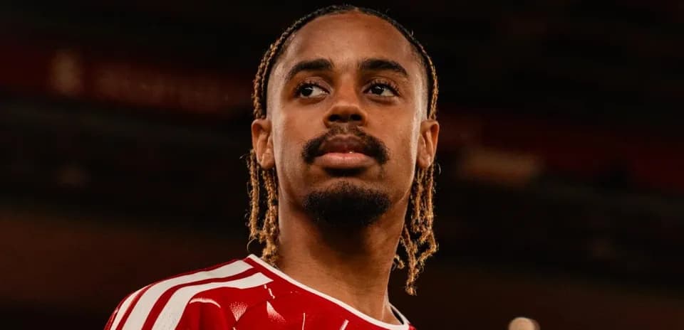 Joueur avec maillot rouge regardant au loin