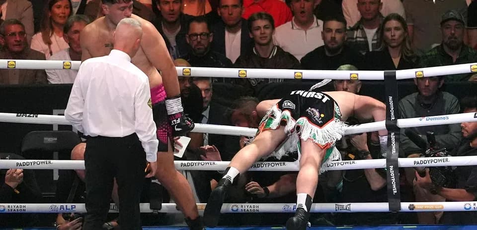 Boxer falling against the ropes during a match