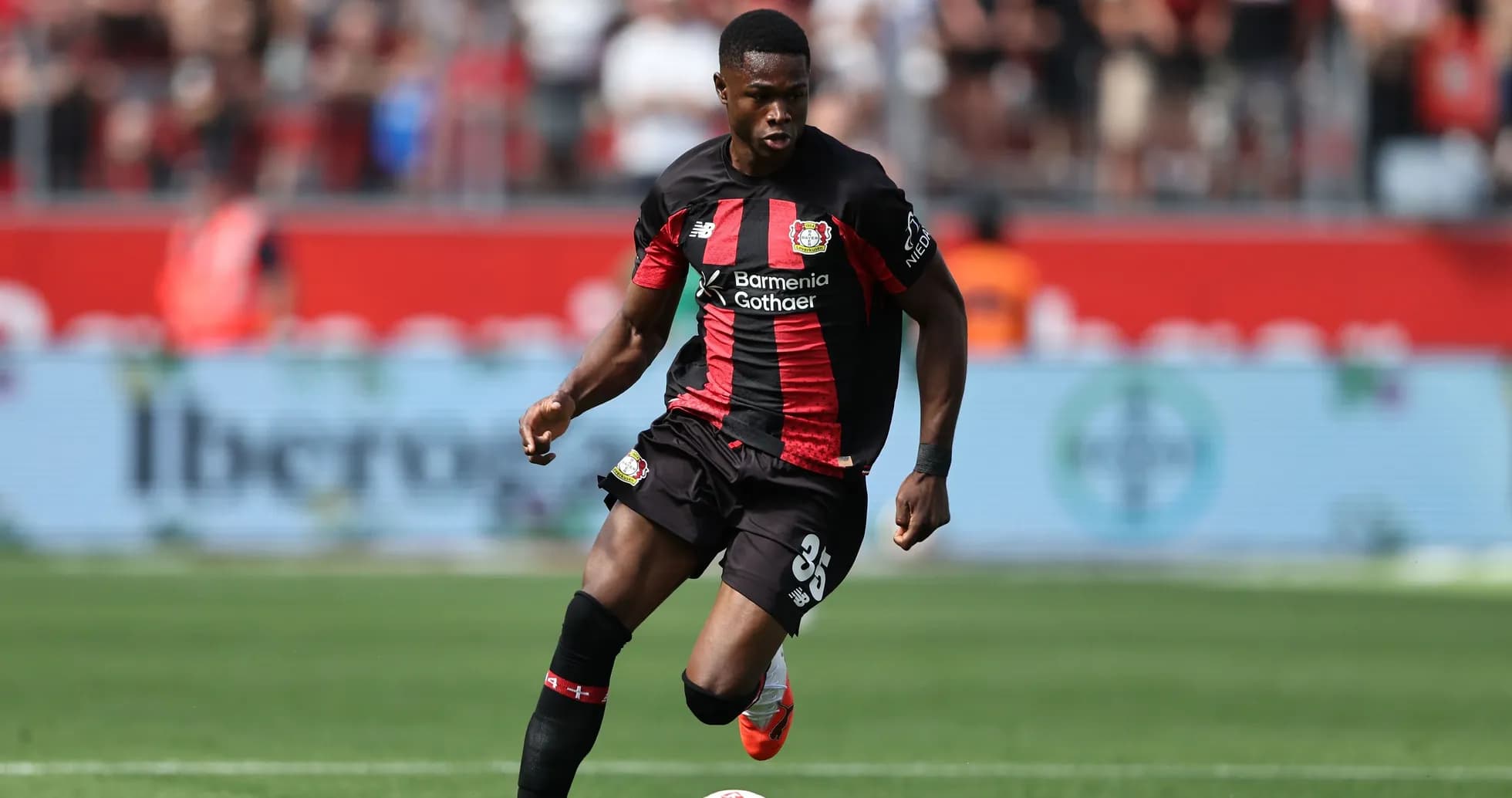 Joueur dribblant le ballon sur le terrain de football