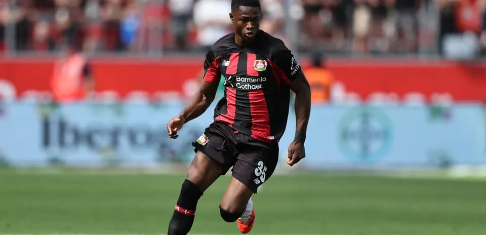 Joueur dribblant le ballon sur le terrain de football
