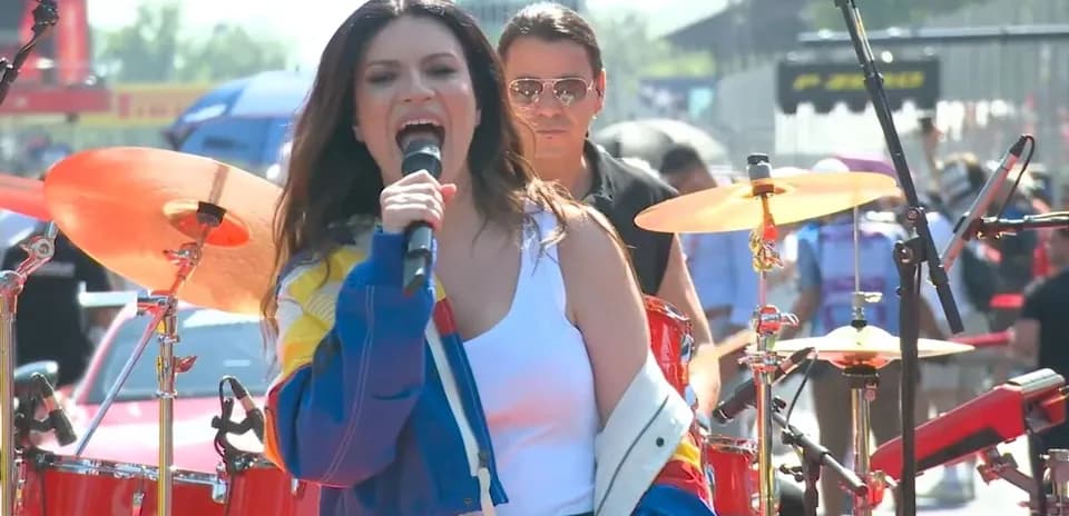 Artiste chantant sur scène avec musiciens en arrière-plan