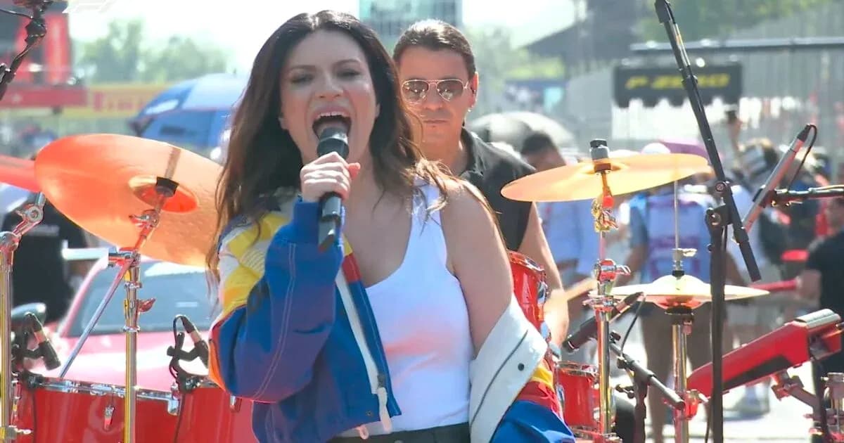 Artiste chantant sur scène avec musiciens en arrière-plan