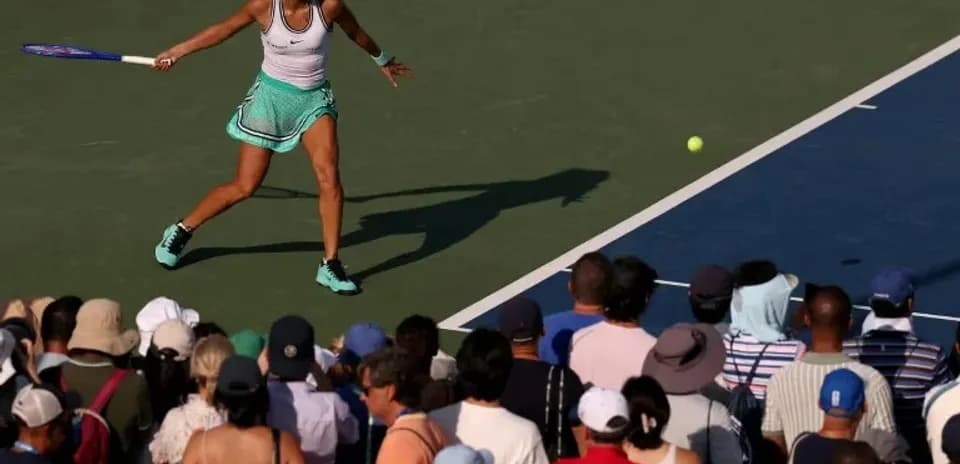 Joueuse de tennis frappant une balle devant le public