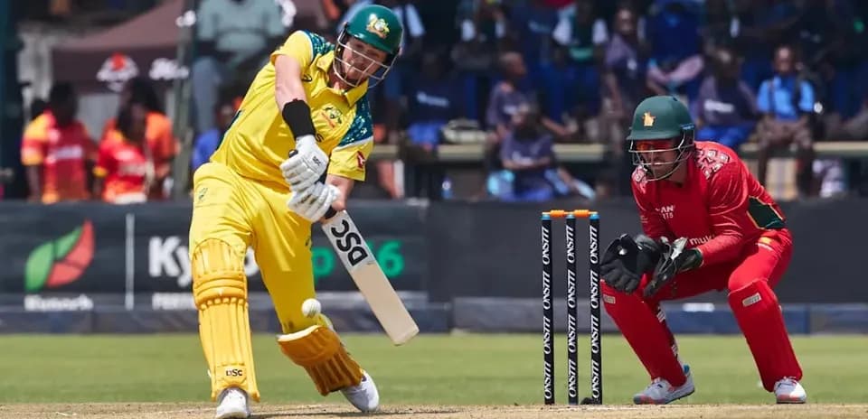 Batsman playing shot while wicketkeeper prepares to catch