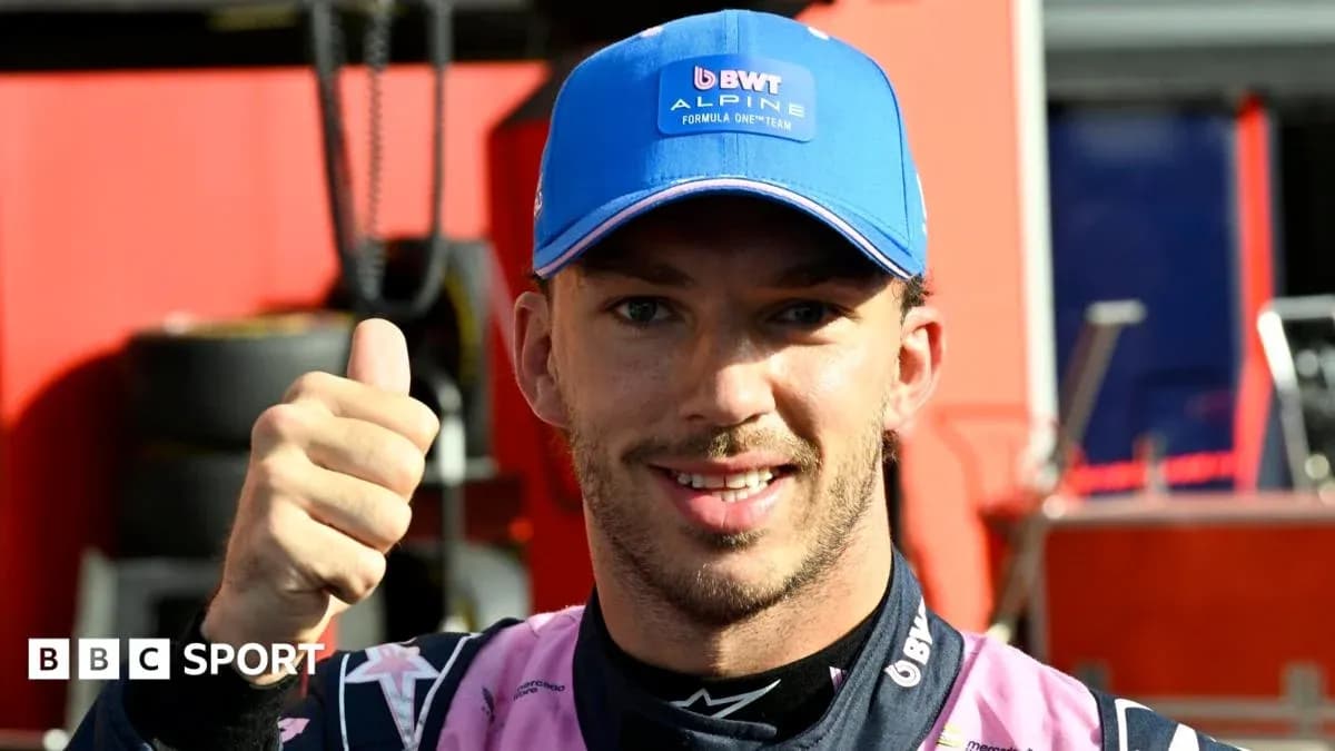 Pilote avec un pouce levé en tenue de course