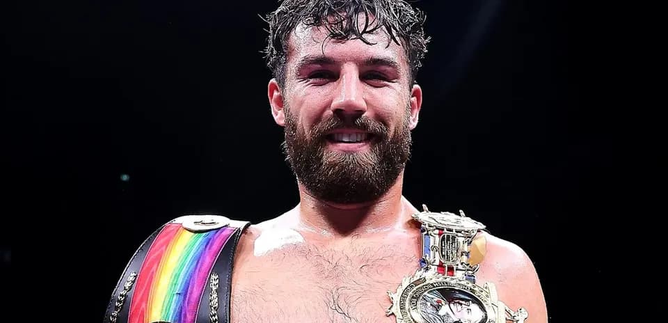 Boxeur souriant avec ceintures de champion