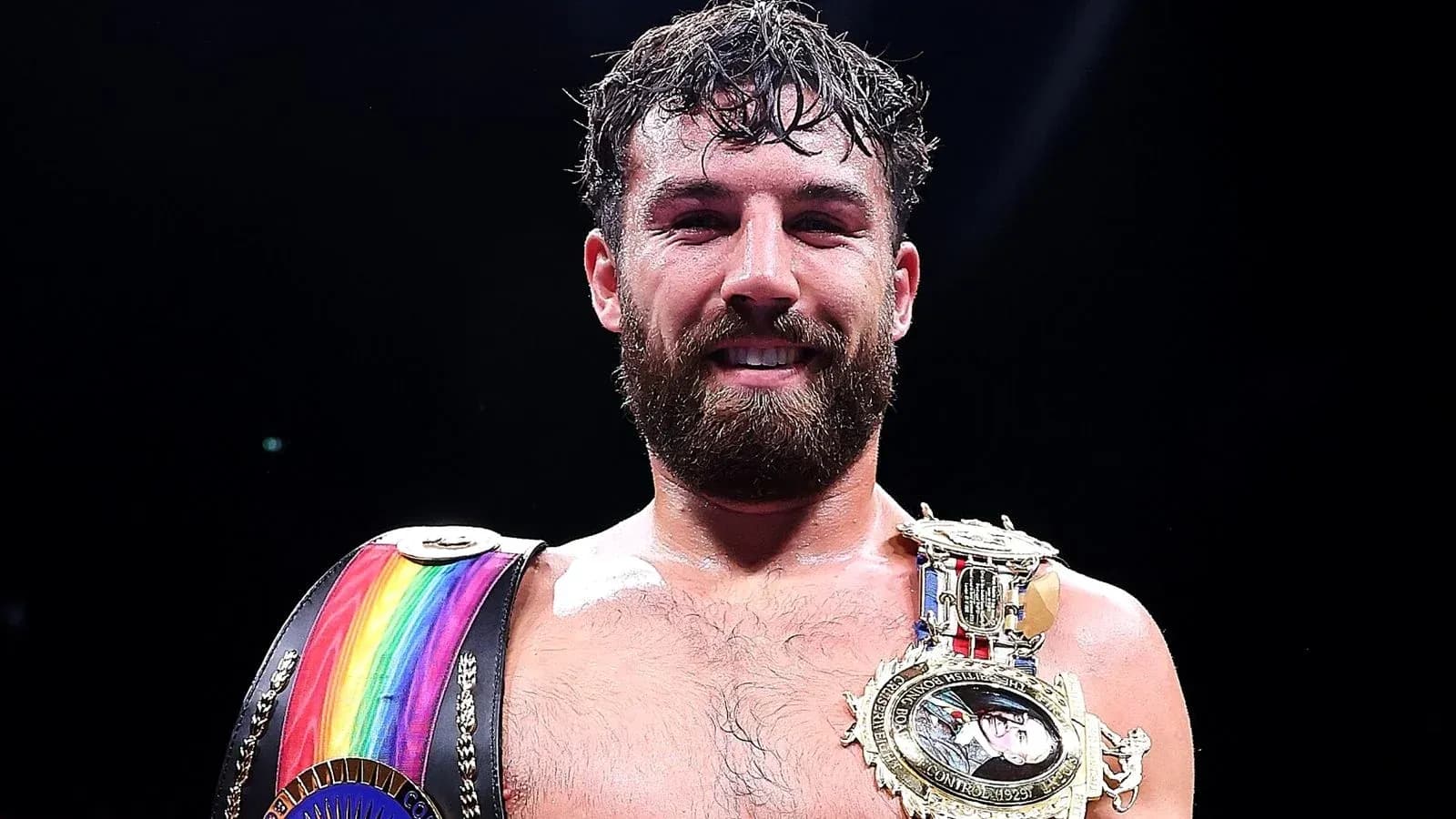 Boxeur souriant avec ceintures de champion