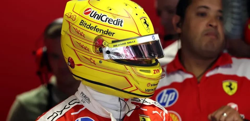 Pilote en combinaison Ferrari avec casque jaune dans les stands