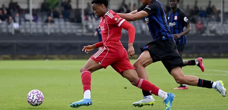 Joueur en rouge dribblant un adversaire en bleu