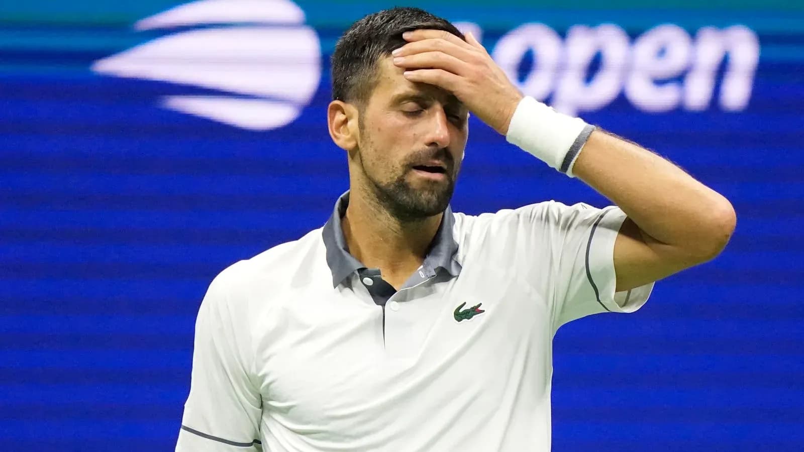 Joueur de tennis se tenant le front pendant un match