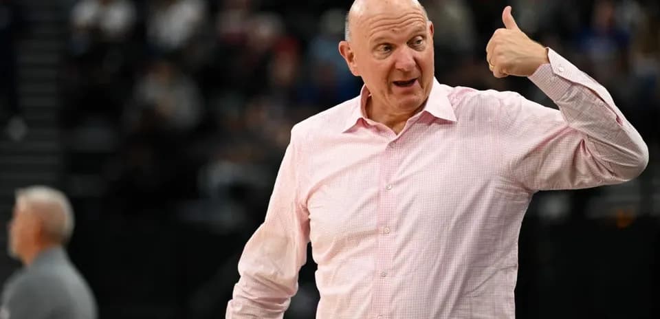 Homme en chemise rose faisant un geste pendant un match