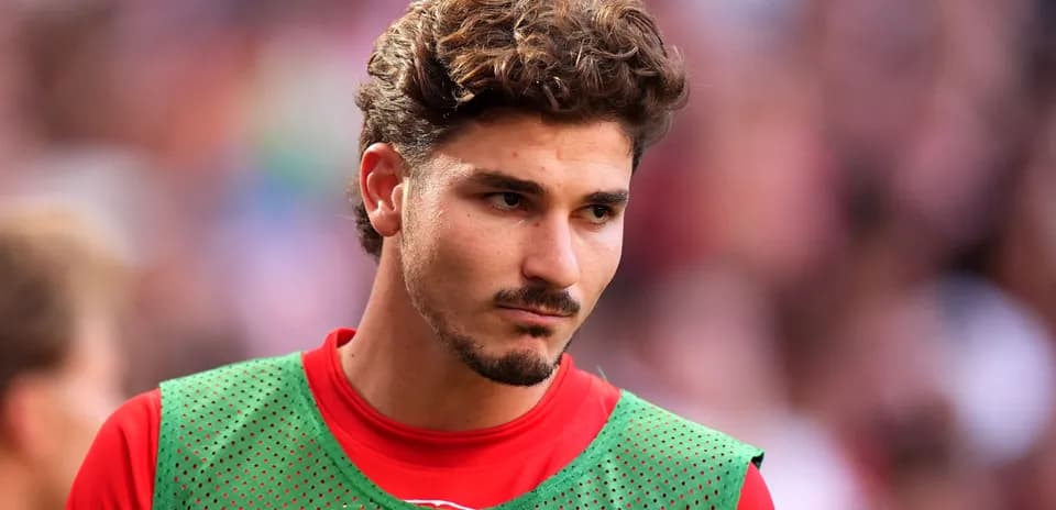 Joueur en survêtement vert sur le terrain de football