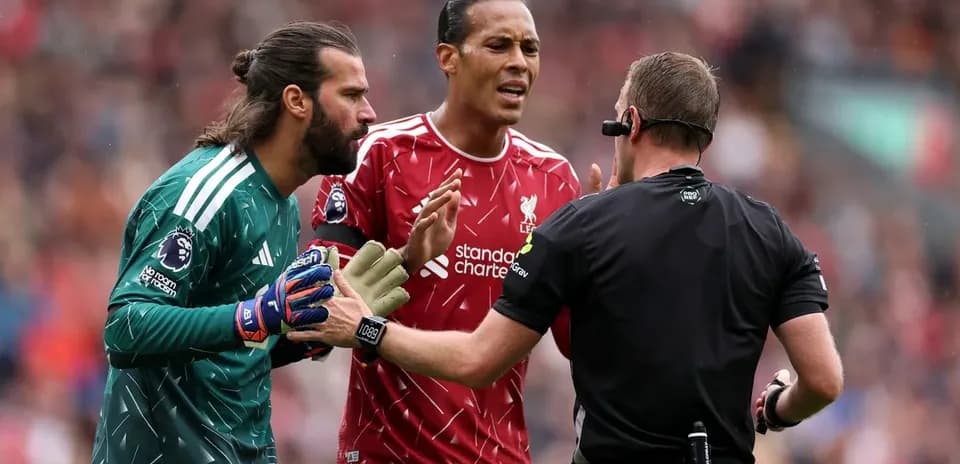 Joueurs de Liverpool discutant avec l'arbitre