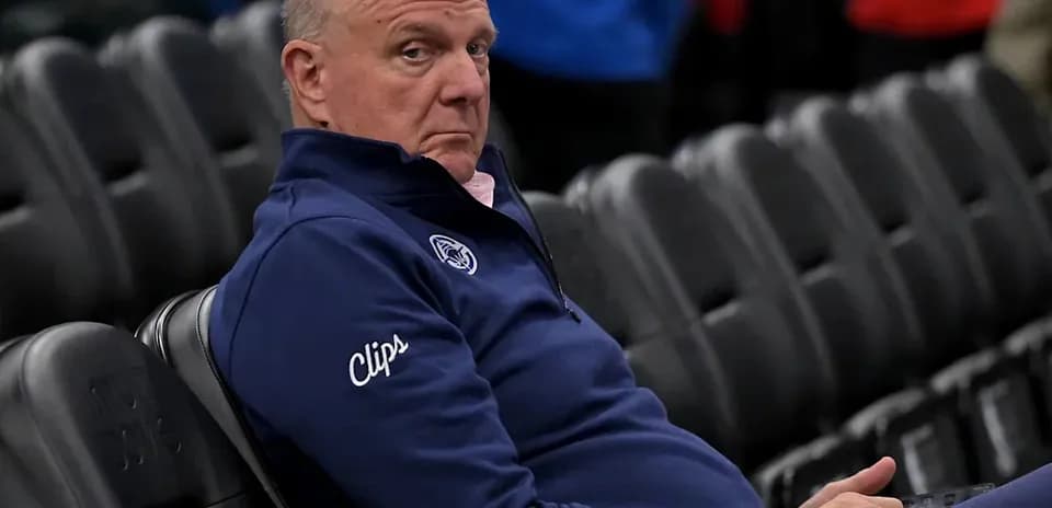 Homme assis sur un siège, portant un pull bleu