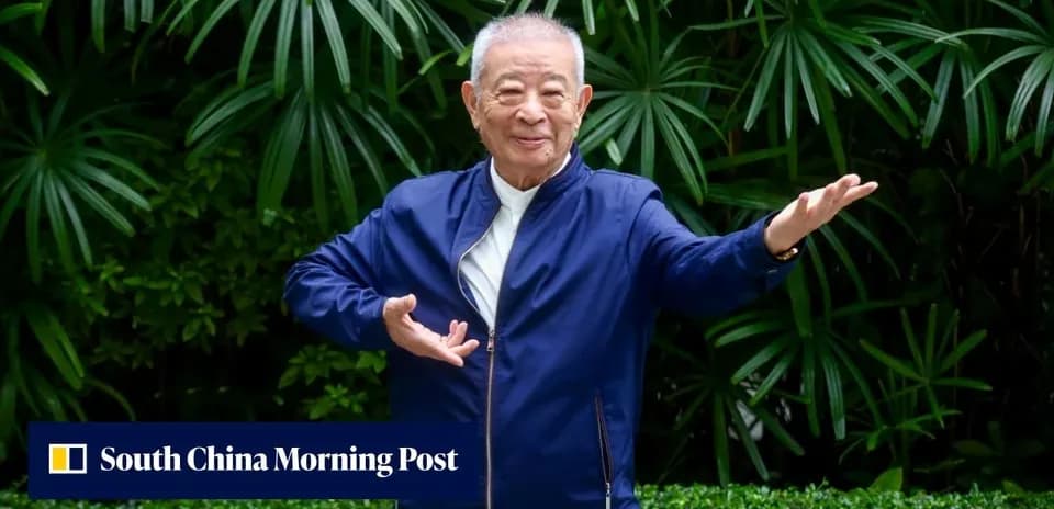 Homme souriant posant devant des plantes vertes