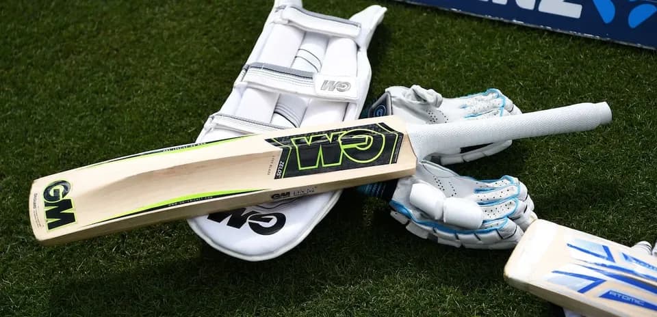 Bat and cricket gear on grass surface