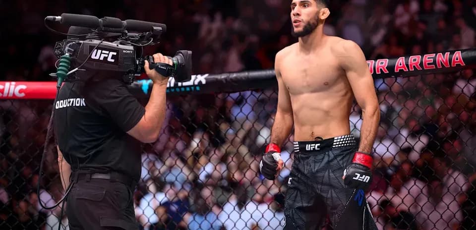 Fighter standing in octagon with camera crew