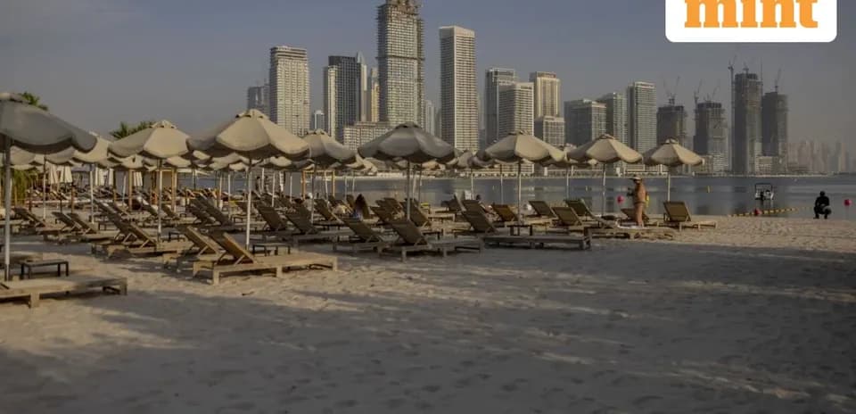 Plage avec chaises longues et buildings en arrière-plan
