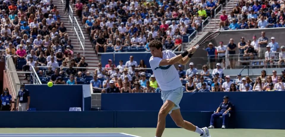 Joueur de tennis frappant une balle sous les projecteurs