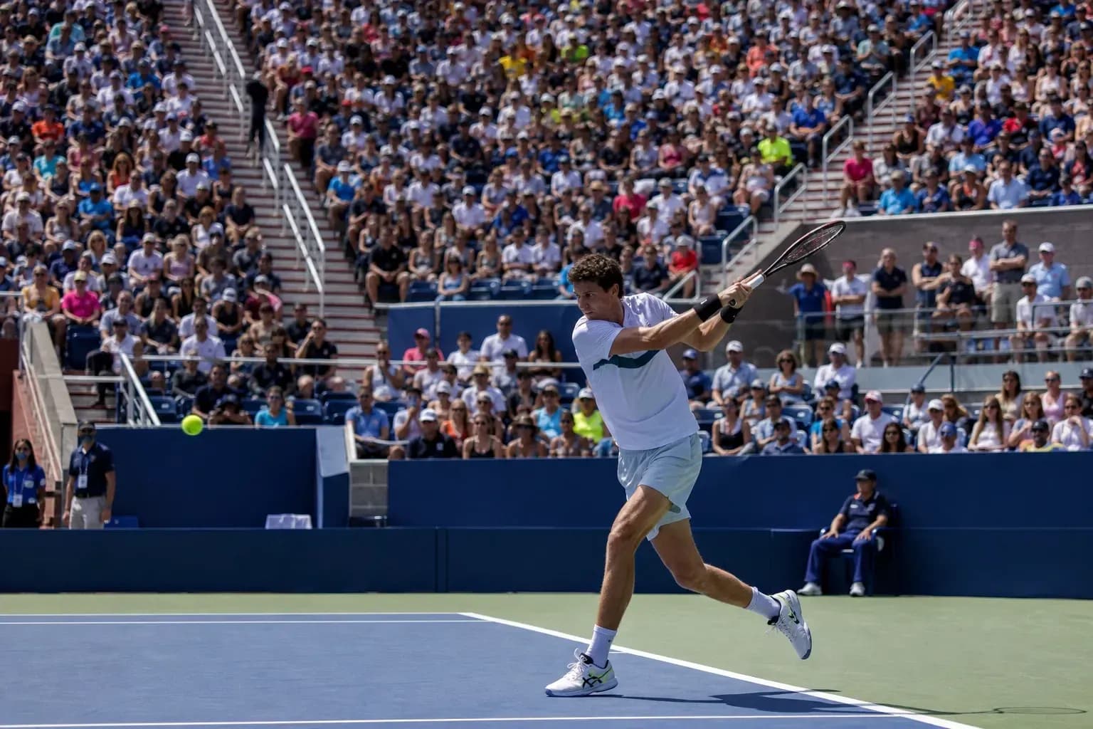 Joueur de tennis frappant une balle sous les projecteurs