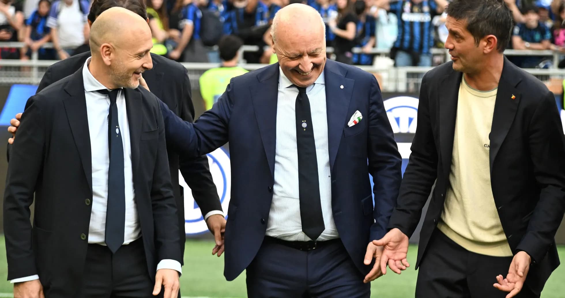 Trois entraîneurs discutant sur le terrain de football