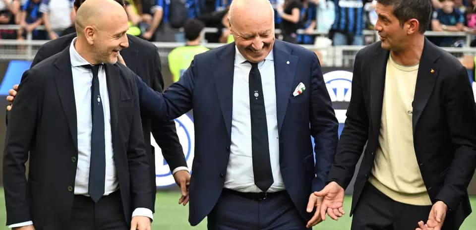 Trois entraîneurs discutant sur le terrain de football