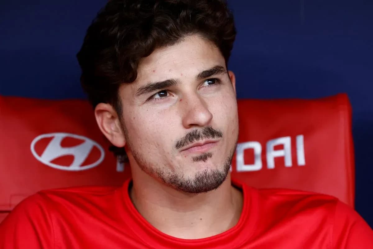 Joueur assis sur le banc de touche en tenue rouge