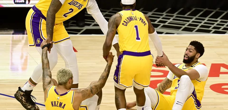 Joueurs des Lakers aidant Kuzma et Davis au sol