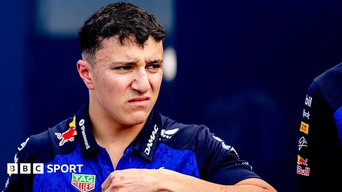 Pilote en tenue de course se tenant sur le circuit