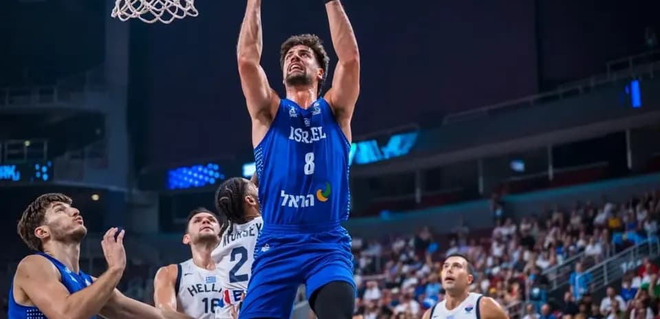 Joueur israélien dunkant pendant un match de basket