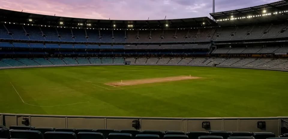 Stade de cricket vide avec terrain au crépuscule