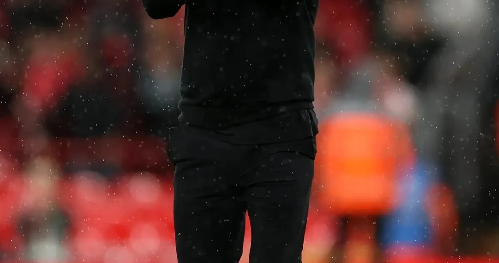 Entraîneur applaudissant sur le terrain sous la pluie