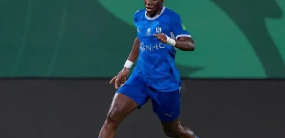 Joueur dribblant le ballon sur le terrain de football