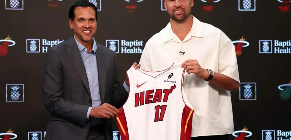 Entraîneur et joueur présentant le maillot des Heat