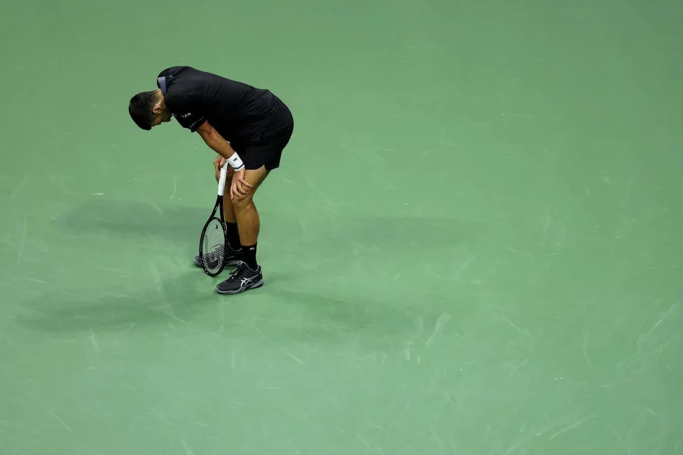Joueur de tennis se penchant avec sa raquette
