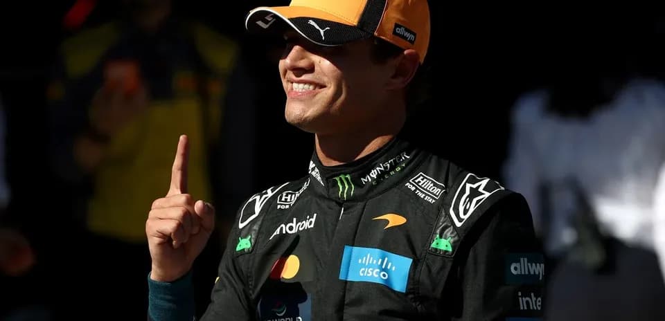 Pilote de F1 en combinaison McLaren faisant un geste