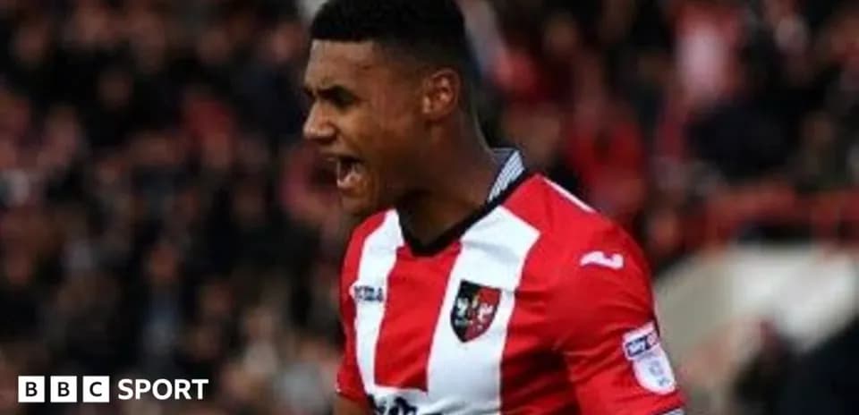 Joueur célébrant un but avec un maillot rouge et noir