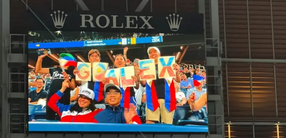 Supporters holding 'GO ALEX' signs at event