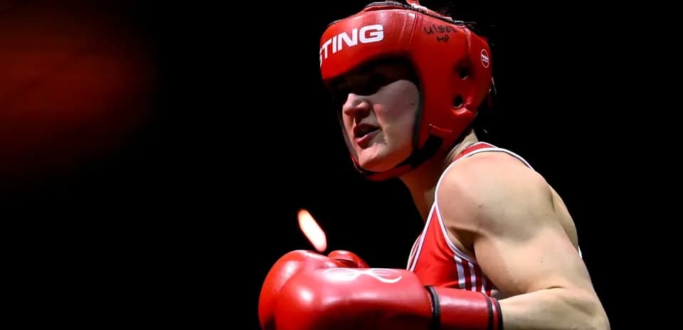 Boxeuse en action avec casque et gants rouges
