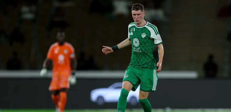 Joueur en vert dribbles sur le terrain de football