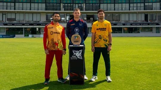 Trois joueurs posant avec le trophée sur le terrain