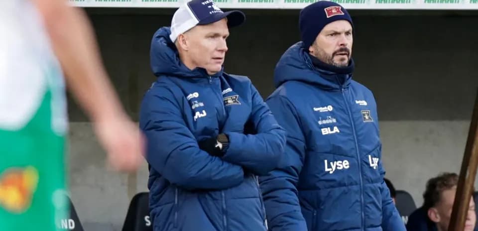 Deux entraîneurs observant le match depuis le banc