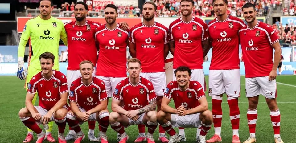 Équipe de football posant en tenue rouge sur le terrain