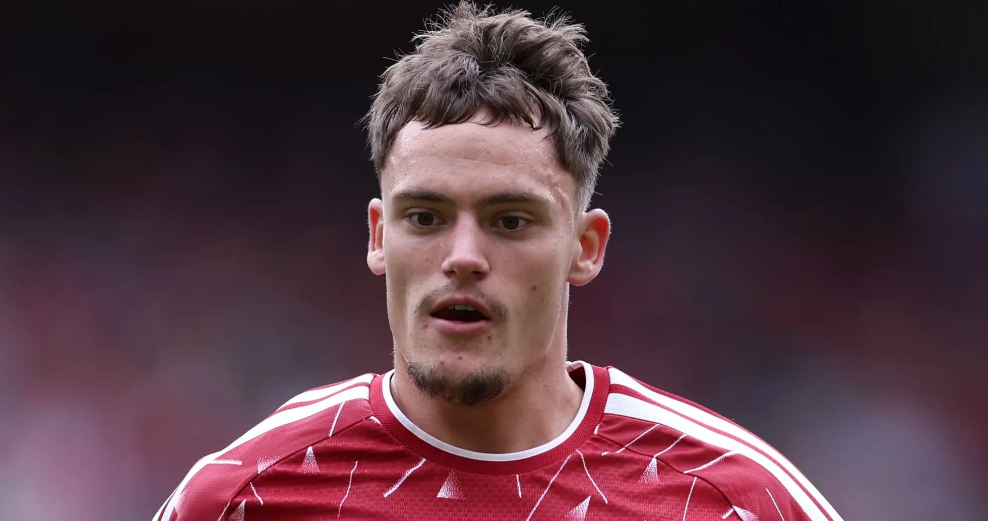 Joueur en maillot rouge avec cheveux ébouriffés