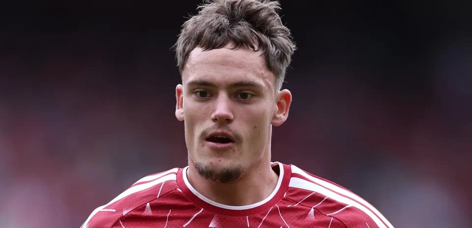 Joueur en maillot rouge avec cheveux ébouriffés