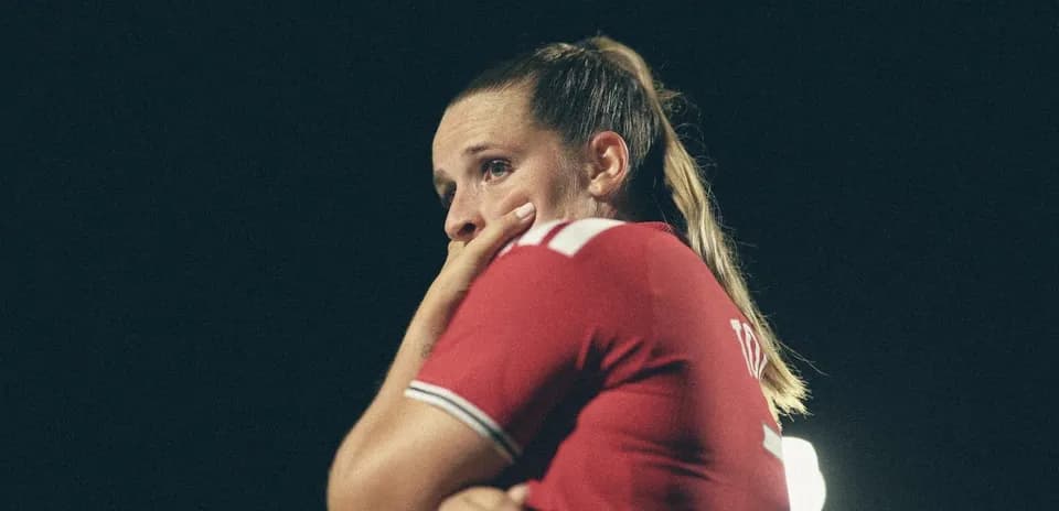 Joueuse en maillot rouge, pensive sur le terrain
