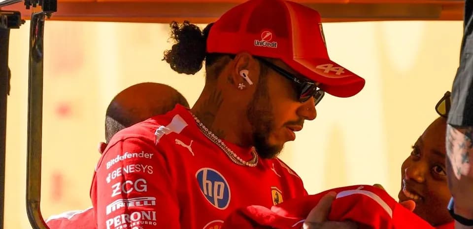 Pilote en combinaison Ferrari interagissant avec une personne