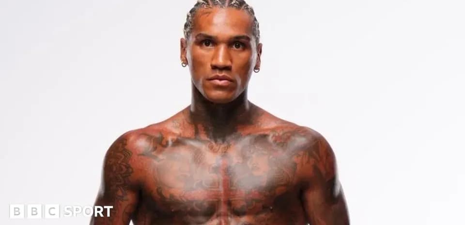 Athlete posing with visible tattoos and braided hair